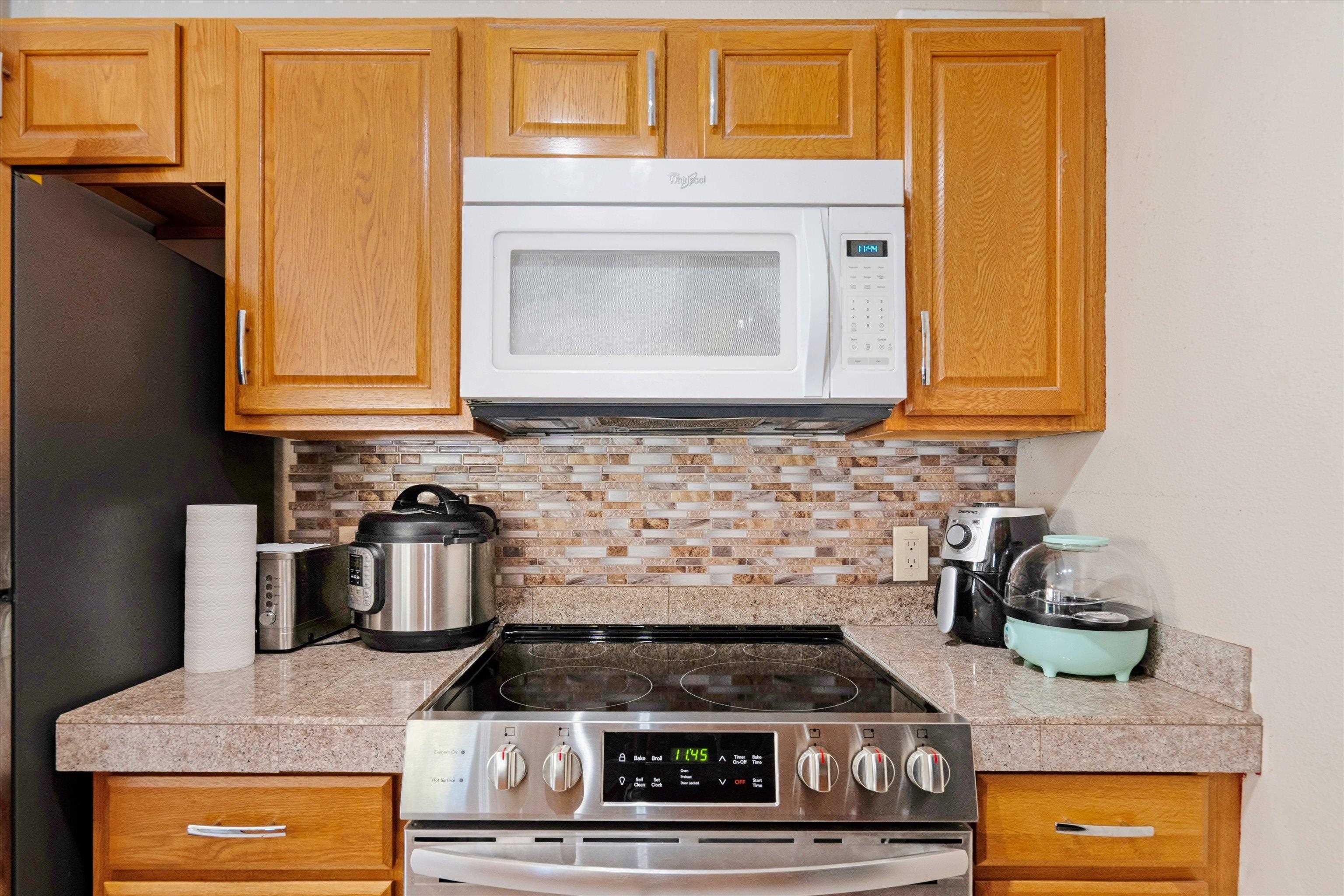 140 Uwapo Road, Unit 19105 Kihei, HI 96753 - Photo 7 of 42 a kitchen with stainless steel appliances granite countertop a stove and a microwave