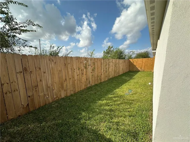 a view of yard with swimming pool and wooden fence