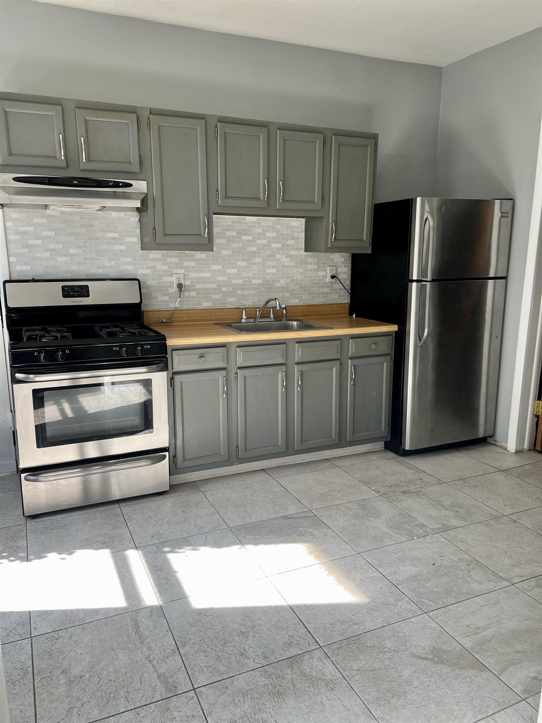 417 9th Street Rockford, IL 61104 - Photo 5 of 11 a kitchen with granite countertop a stove a refrigerator and a cabinets