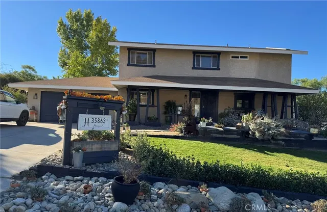 a view of a house with backyard outdoor seating area and green space