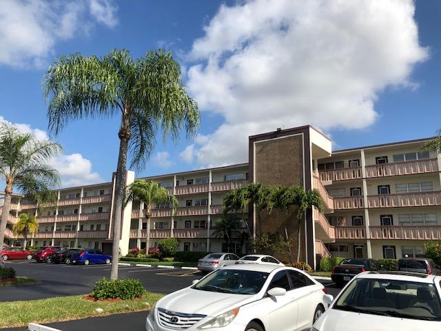 1044 Rexford Drive Boca Raton, FL 33434 - Photo 1 of 50 a front view of a building with parking space and palm trees
