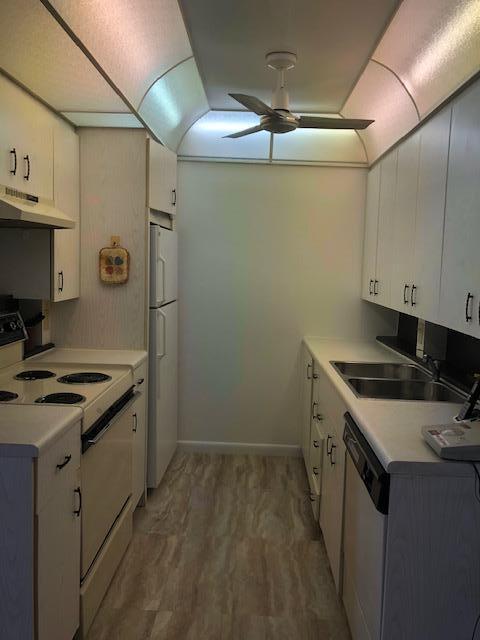 1044 Rexford Drive Boca Raton, FL 33434 - Photo 14 of 50 a kitchen that has a sink a stove and wooden floor