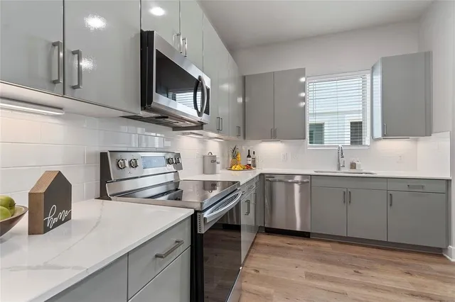 a kitchen with stainless steel appliances granite countertop a sink and a stove