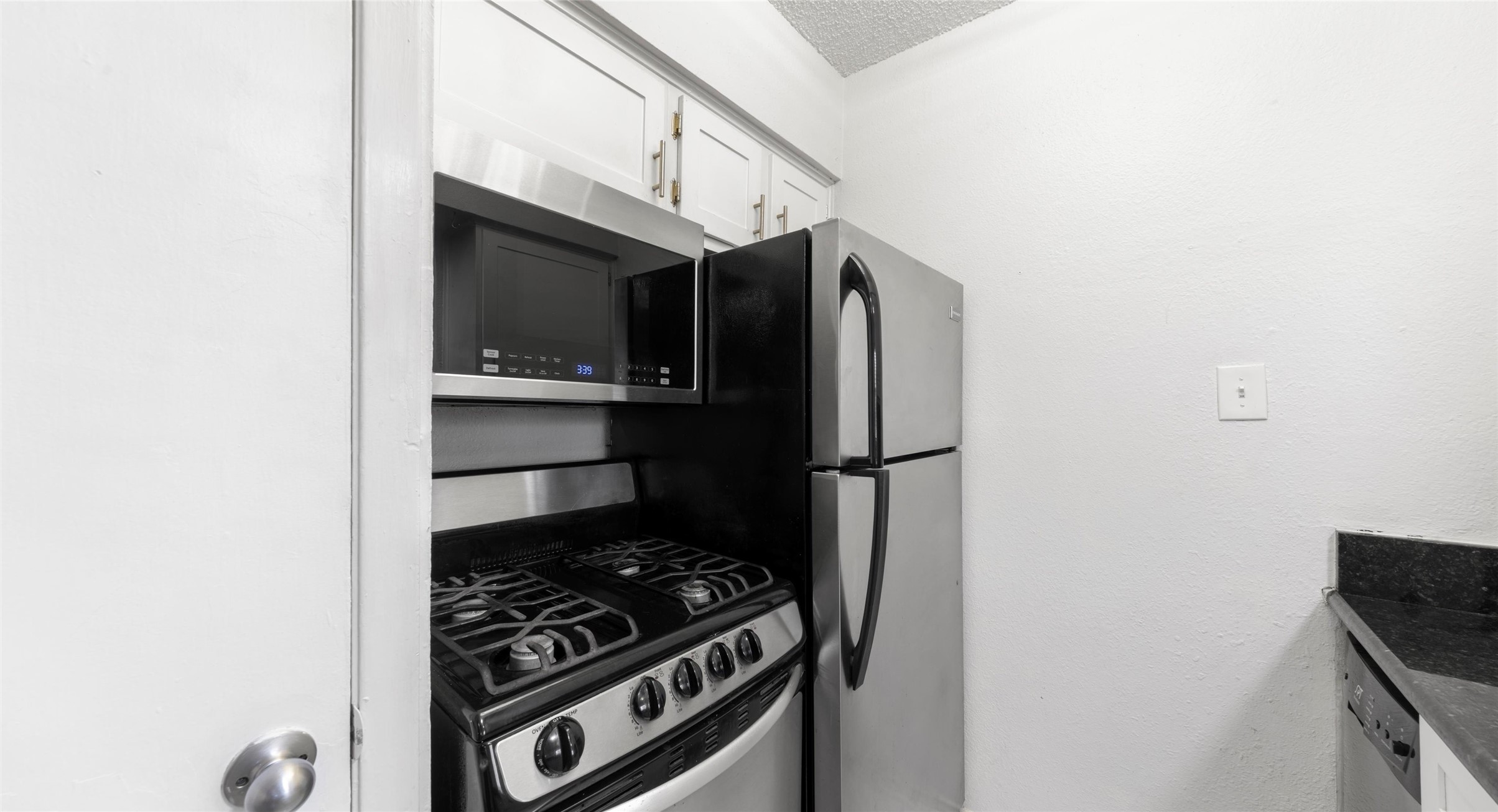 2401 Manor Road, Unit 123 Austin, TX 78722 - Photo 9 of 22 Compact and efficient, this kitchen features modern stainless steel appliances within a well-utilized layout.