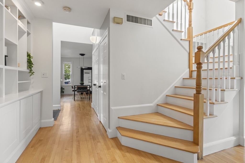 169 Walnut Street, Unit 2 Boston, MA 02122 - Photo 8 of 42 a view of staircase with white walls and wooden floor
