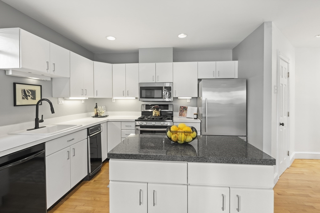 169 Walnut Street, Unit 2 Boston, MA 02122 - Photo 9 of 42 a kitchen with a sink a microwave and refrigerator