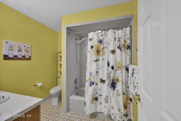 a bathroom with a toilet and a shower curtain
