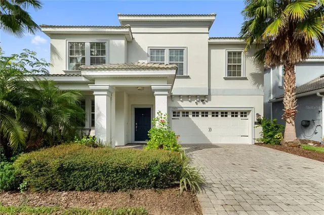 a front view of a house with yard and parking