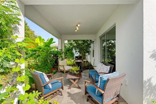 a living room with patio furniture and a potted plant