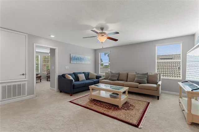 a living room with furniture a ceiling fan and a window