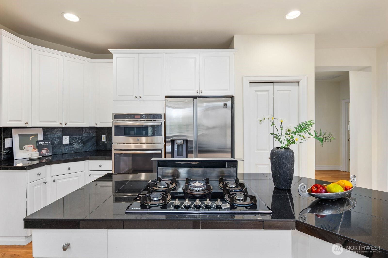 3429 Lincoln Avenue Northeast Renton, WA 98056 - Photo 13 of 40 a kitchen with stainless steel appliances kitchen island granite countertop a sink a stove and white cabinets