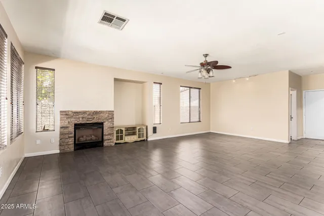 an empty room with fireplace and windows