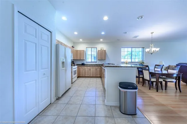 a open kitchen with kitchen island granite countertop a large counter top space and stainless steel appliances