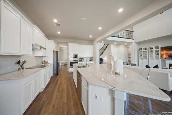 a large kitchen with kitchen island a large counter space a sink appliances and cabinets