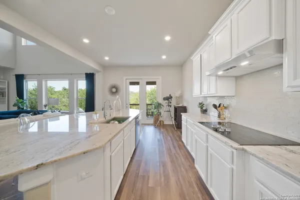 a large kitchen with granite countertop a large counter top appliances and cabinets