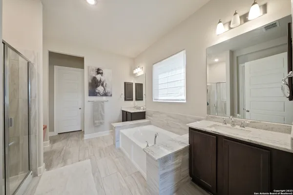 a spacious bathroom with a granite countertop sink mirror and bathtub