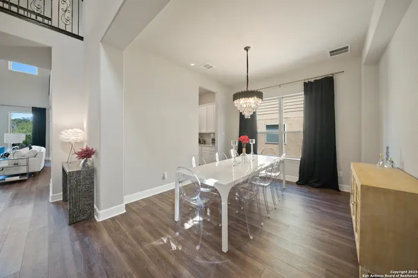 a view of a dining room and livingroom with furniture wooden floor a chandelier