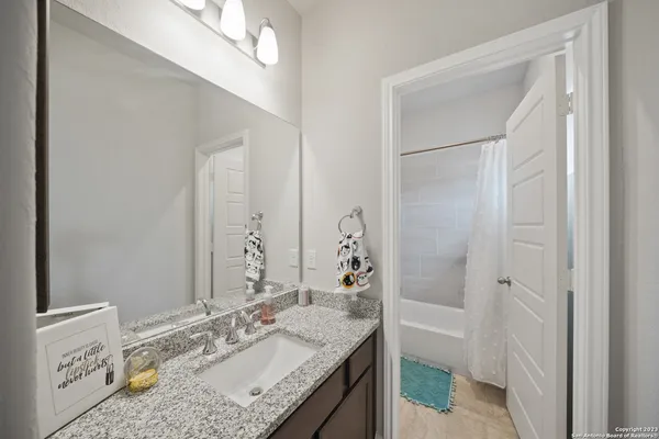 a bathroom with a granite countertop sink and a mirror