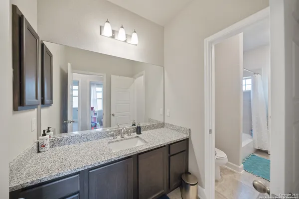 a bathroom with a granite countertop sink and a mirror