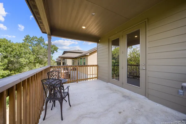 a view of a porch with chairs and backyard of the house