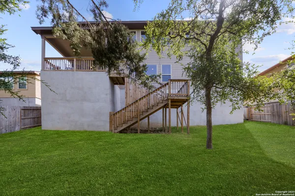 a view of a house with a yard and a tree