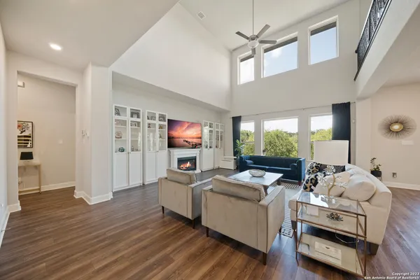 a living room with furniture a flat screen tv and a floor to ceiling window