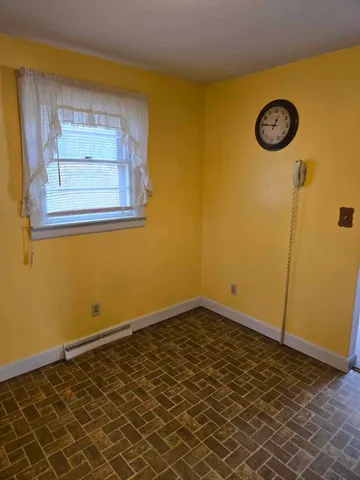 a view of a room with wooden floor and a table