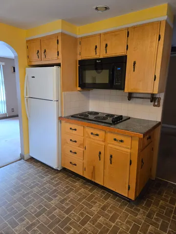 a kitchen with granite countertop a refrigerator and a stove