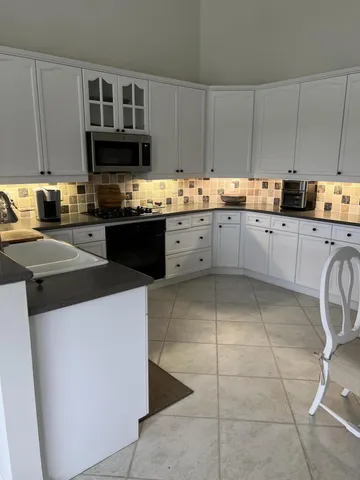 a kitchen with stainless steel appliances a sink a stove a microwave and cabinets