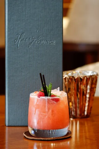 a room with lots of tables a chandelier and couches
