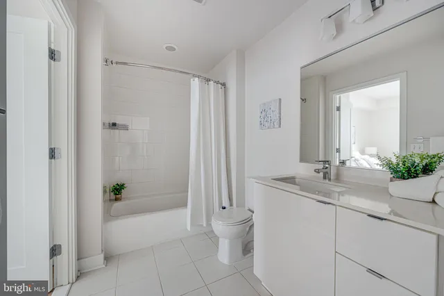 a bathroom with a granite countertop sink a toilet and shower