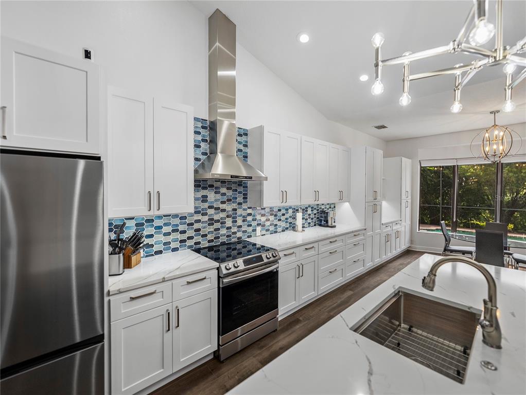 34120 Americana Avenue Dade City, FL 33525 - Photo 18 of 71 a kitchen with stainless steel appliances granite countertop a sink stove and refrigerator