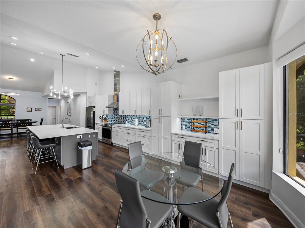 34120 Americana Avenue Dade City, FL 33525 - Photo 26 of 71 a kitchen with a dining table chairs refrigerator and cabinets