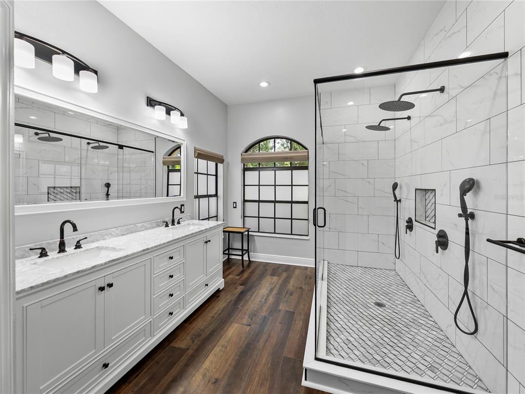 34120 Americana Avenue Dade City, FL 33525 - Photo 34 of 71 a bathroom with a double vanity sink toilet mirror and bathtub