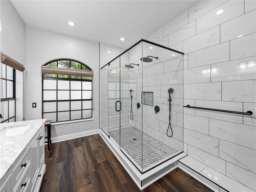 34120 Americana Avenue Dade City, FL 33525 - Photo 35 of 71 a bathroom with a granite countertop sink a mirror and shower