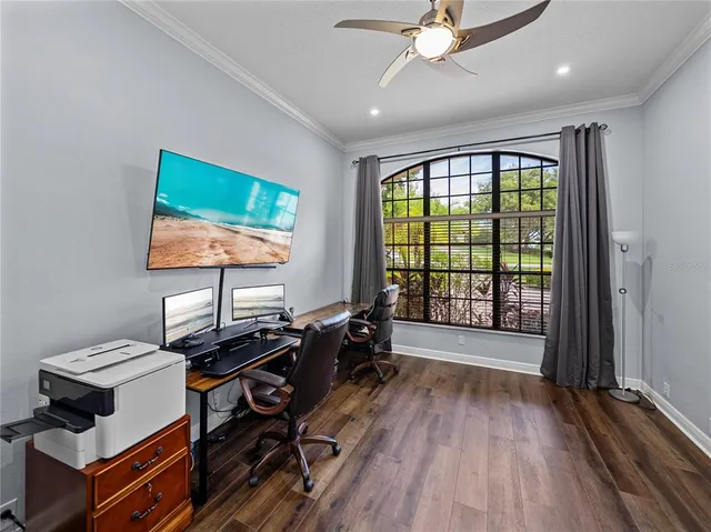 a bedroom with a bed and dresser with wooden floor