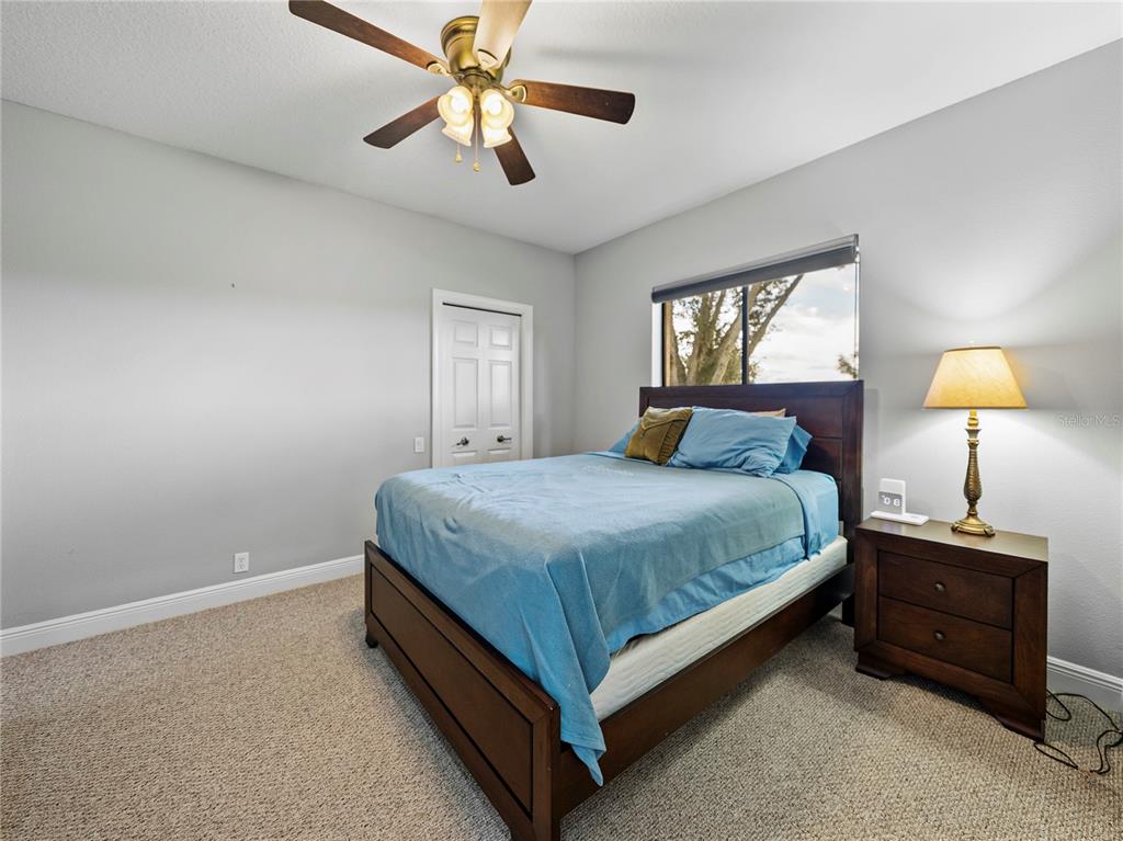 34120 Americana Avenue Dade City, FL 33525 - Photo 40 of 71 a bedroom with a bed and a chandelier