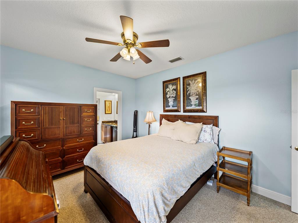 34120 Americana Avenue Dade City, FL 33525 - Photo 45 of 71 a bedroom with a bed and dresser with wooden floor