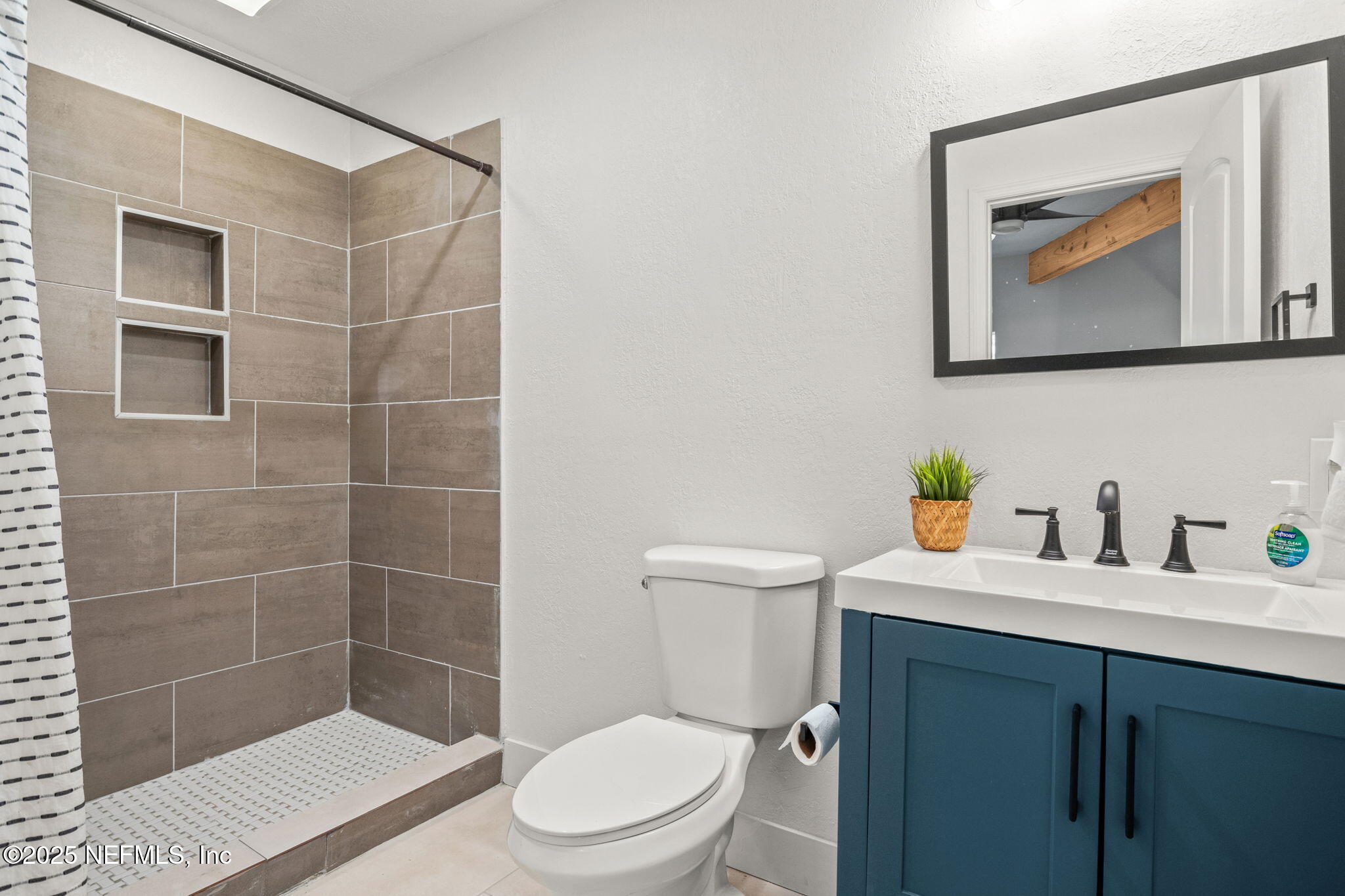 10024 Sandler Road Jacksonville, FL 32222 - Photo 19 of 40 a bathroom with a toilet a sink a mirror and shower