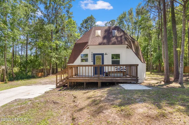 a view of a house with a yard and furniture