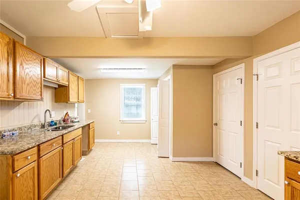 a spacious bathroom with a granite countertop sink a mirror and a bathtub