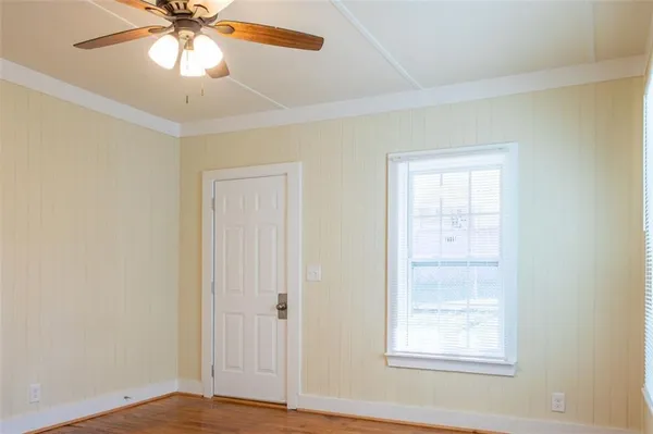 an empty room with windows and fan