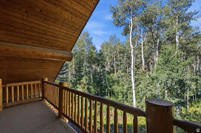 11192 Maple Road, Unit 7 Heber City, UT 84032 - Photo 27 of 51 Wood-paneled ceiling, exposed wooden beams, natural wood railing, and a wooded natural setting