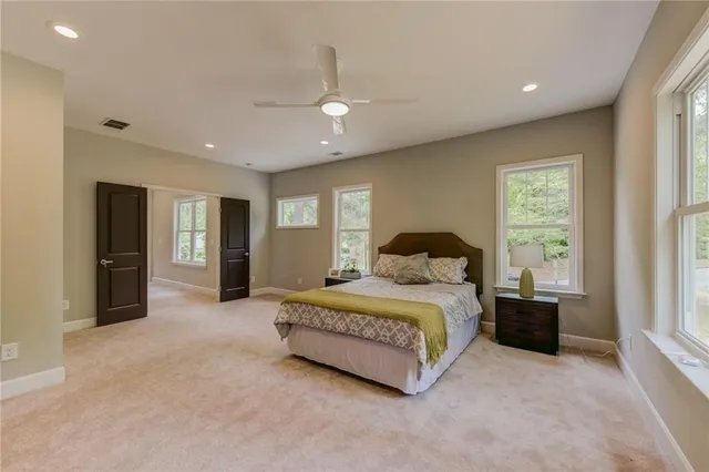 a spacious bedroom with a bed and a large window
