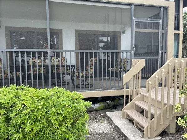 a view of a house with wooden deck and furniture