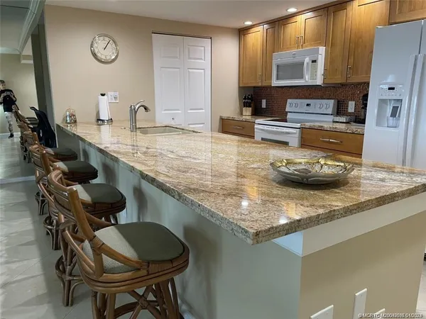 a kitchen with a sink a stove and chairs