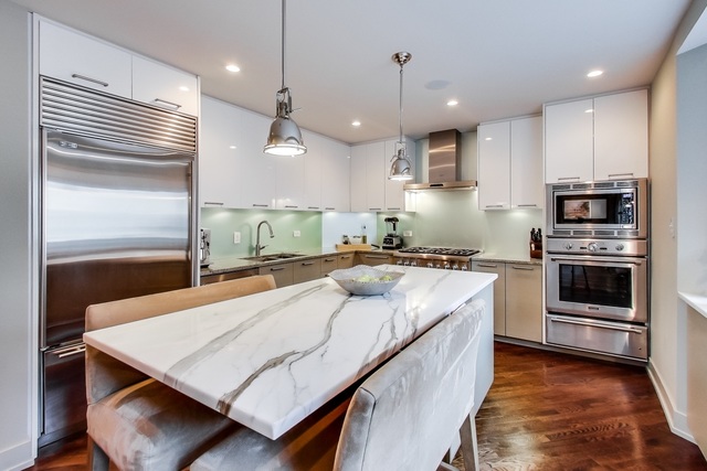 55 West Goethe Street, Unit 1233 Chicago, IL 60610 - Photo 11 of 31 a large kitchen with kitchen island a stove a sink a refrigerator and a wooden floor