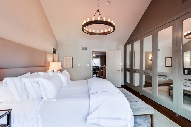 55 West Goethe Street, Unit 1233 Chicago, IL 60610 - Photo 24 of 31 a large bedroom with a large bed and a chandelier