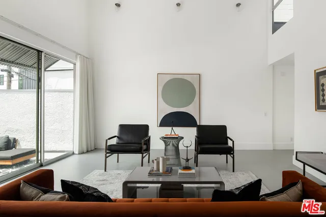 a living room with furniture and floor to ceiling window