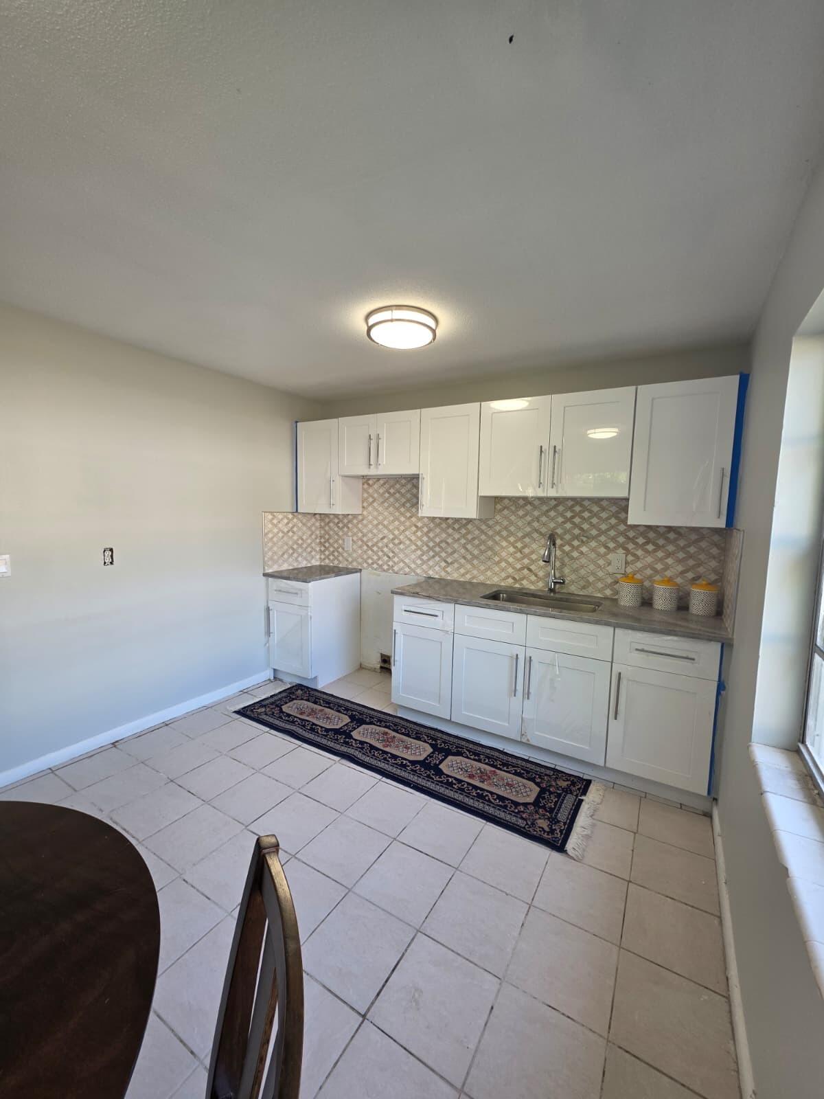 3386 Rudolph Road Lake Worth Beach, FL 33461 - Photo 13 of 25 a kitchen with a stove window and cabinets
